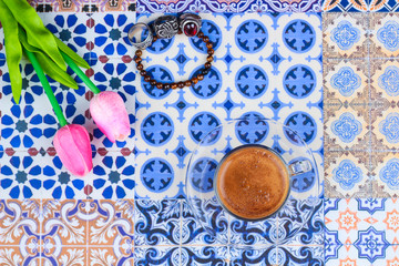 Cup of Arabian Coffee on an Oriental Colorful Background / Cup of Espresso on an Oriental Colorful Background with Flowers, Rings, and Tamr dates 