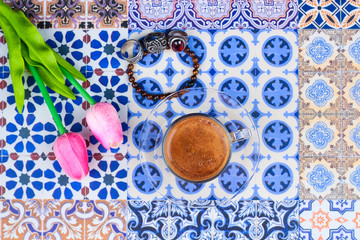 Cup of Arabian Coffee on an Oriental Colorful Background / Cup of Espresso on an Oriental Colorful Background with Flowers, Rings, and Tamr dates 