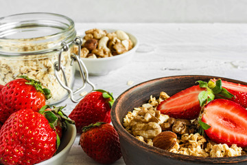 healthy breakfast strawberry muesli with oats, granola and nuts in a bowl