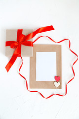 Holiday Post Card Beige Gift Box with Red Ribbon Sheet of Paper White Stone Background 