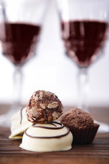 Delicious chocolates on wooden table closeup