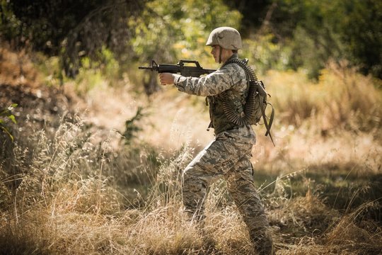 Military soldier aiming with a rifle