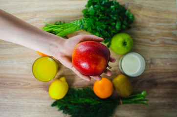 In the hand of the Apple on a background of vegetables