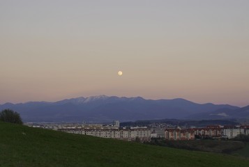 Full moon over the mountains and city. Slovakia