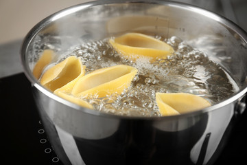 Cooking pasta in pan on stove, closeup