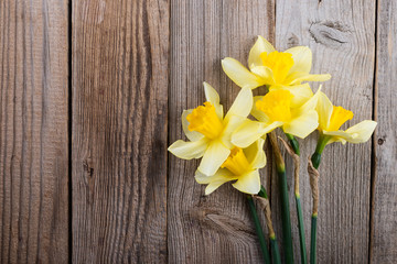 Beautiful yellow narcissus (daffodils)  on rustic wooden background. Colorful  card for Mothers Day. Top view  and copy space