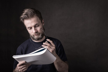 Caucasian man in casual t-shirt reading documents