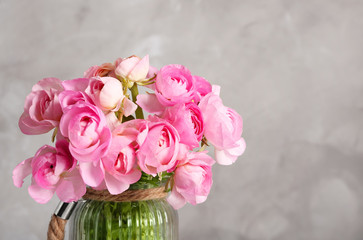 Beautiful bouquet of ranunculus flowers on color background