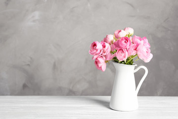 Vase with beautiful bouquet of ranunculus flowers on table