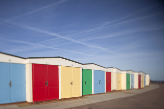 A row of colourful beach huts on the seafront at Exmouth, Devon, UK