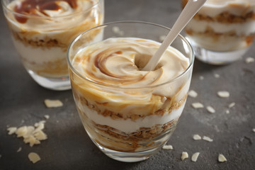 Glass with tasty yogurt dessert on table