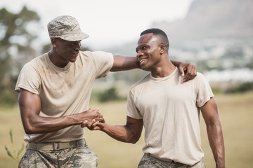 Military soldiers shaking hands during obstacle course