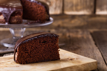 Slice of homemade chocolate cake on wooden table