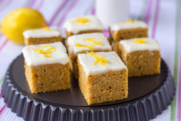 Pieces of homemade carrot cake with orange, lemon zest and icing cream. Selective focus
