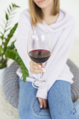 Glass of red wine. Young woman holding a glass