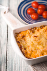 Homemade Meat lasagna and tomato on wooden stand