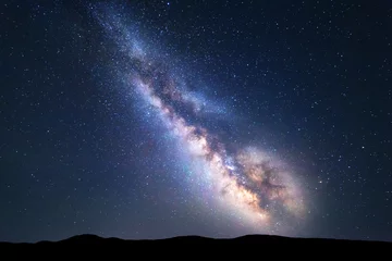 Fotobehang Melkweg. Kleurrijk nachtlandschap met heldere melkweg, sterrenhemel en heuvels in de zomer. Ruimte achtergrond. Geweldige astrofotografie. Prachtig universum. Reis © den-belitsky