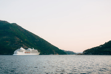 Fototapeta na wymiar Huge cruise ship in the Bay of Kotor in Montenegro. A beautiful country to travel.