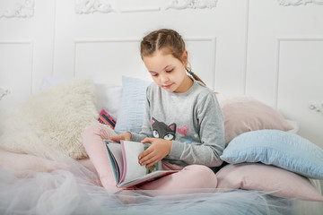 School girl reading a book. The concept of childhood and learning.