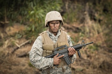 Fototapeta premium Military soldier guarding with a rifle in a boot camp