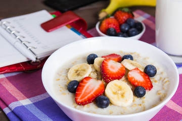 Healthy breakfast with oatmeal, fruits and milk with planning concept