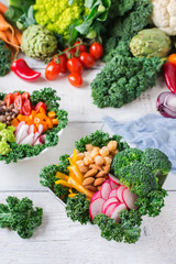 Healthy vegan buddha bowl with kale leaves and raw vegetables