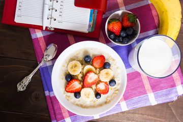 Healthy breakfast with oatmeal, fruits and milk with planning concept