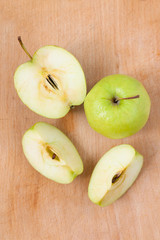 Fresh apples on a wooden Board. Green Apple cut into pieces is on a wooden texture.