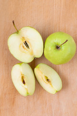 Fresh apples on a wooden Board. Green Apple cut into pieces is on a wooden texture.