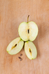 Fresh apples on a wooden Board. Green Apple cut into pieces is on a wooden texture.