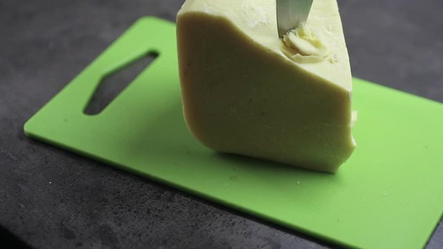piece of cocoa butter is cut with a knife