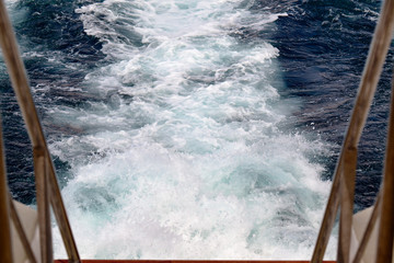 Trail on water surface behind of cruise ship