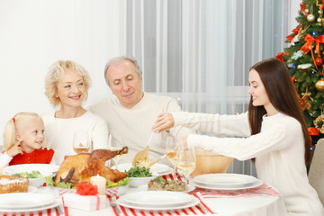 Obraz na płótnie Canvas Happy family having Christmas dinner in living room