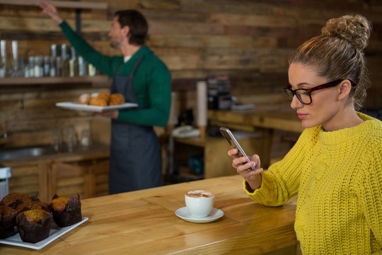 Woman using mobile phone in at coffee shop