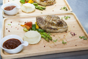  grilled ribeye steak with baked potato and vegetables.