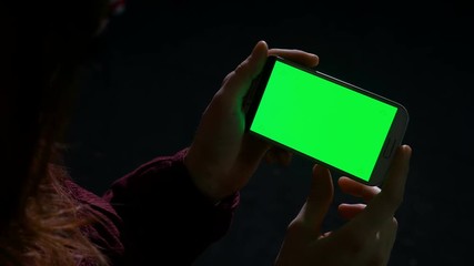 Woman using smart phone in the dark