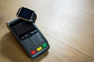 Smart watch and credit card reader on table in coffee shop