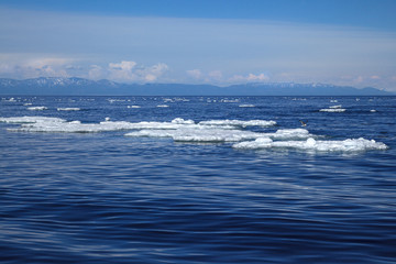 White ice floating on blue water surface