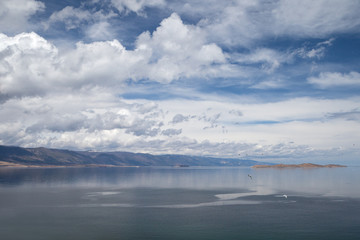 Landscape with beautiful cloudy sky over mountain lake