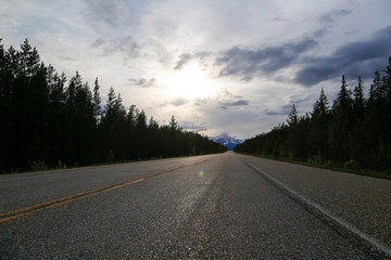 Road between mountains with clouds in the sky