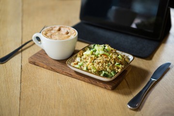 Coffee and food on wooden table in cafeteria