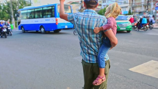 Father Holds in Arms Little Blond Girl Crosses Street in Vietnam