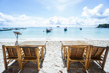 wooden chairs on the beach at seaside for relaxation in bright day