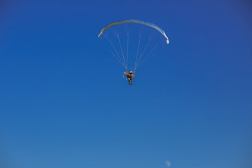 Paragliding flight with blue sky and some clouds