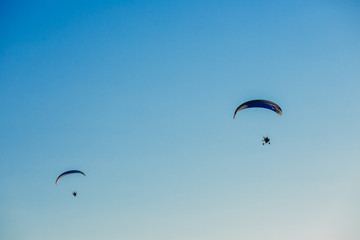 Paragliding flight with blue sky and some clouds