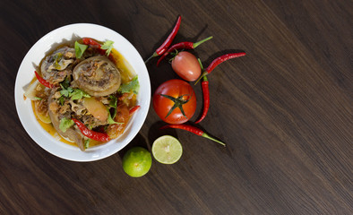 Oxtail soup in white bowl and vegetables for ingredient soup on wooden table Halal food