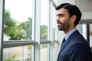 Fototapeta premium Businessman looking through the window
