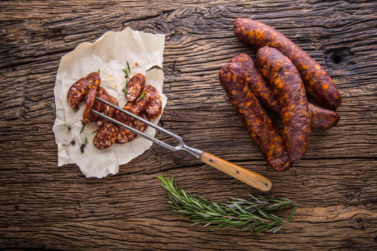 Sausages. Smoked Sausages. Chorizo sausages with vegetable rosemary spices and kitchen utensil.