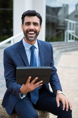 Smiling businessman using digital tablet