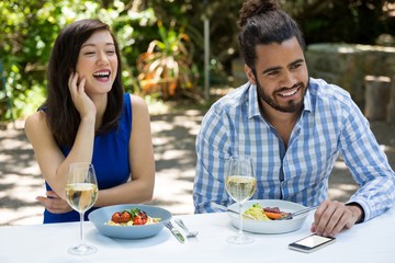 Fototapeta na wymiar Cheerful couple having lunch at outdoor restaurant